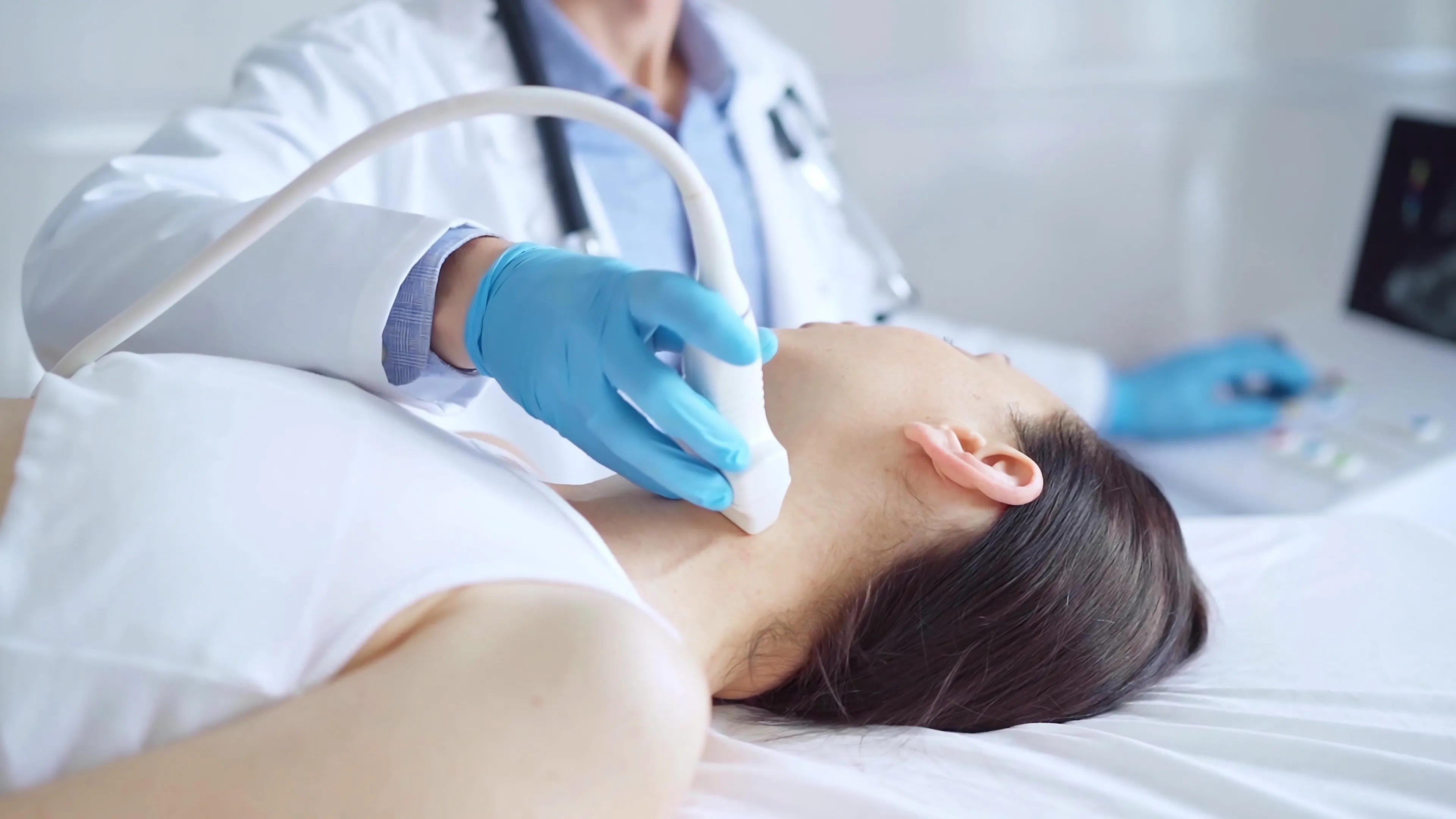 Médica realizando um ultrassound de tireoide em uma paciente