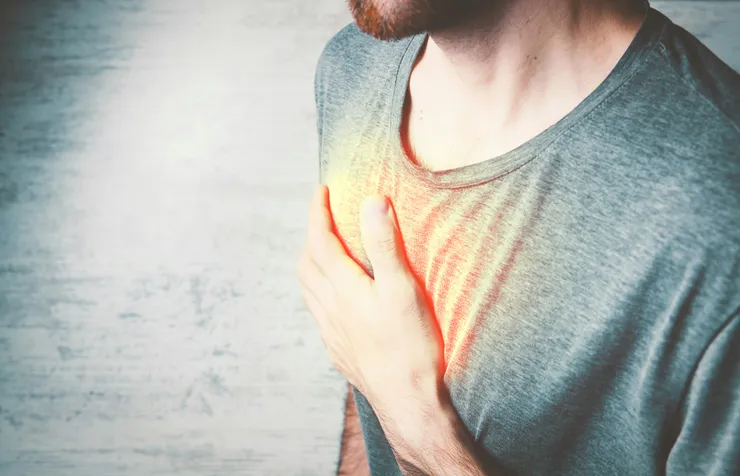 Homem segurando o peito com dor, ilustrando um dos principais sintomas de doenças cardiovasculares abordados pela clínica Biocardio em Macapá.